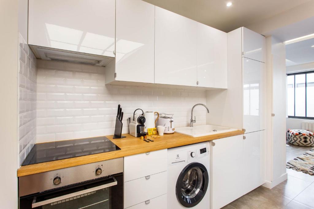 a kitchen with white cabinets and a dishwasher at CMG Oberkampf - Truillot G in Paris