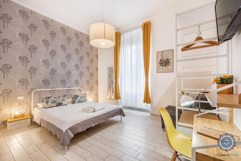 a bedroom with a bed, chair, desk and a lamp at La Casa dei Treni Affittacamere city rooms for travel lovers in La Spezia