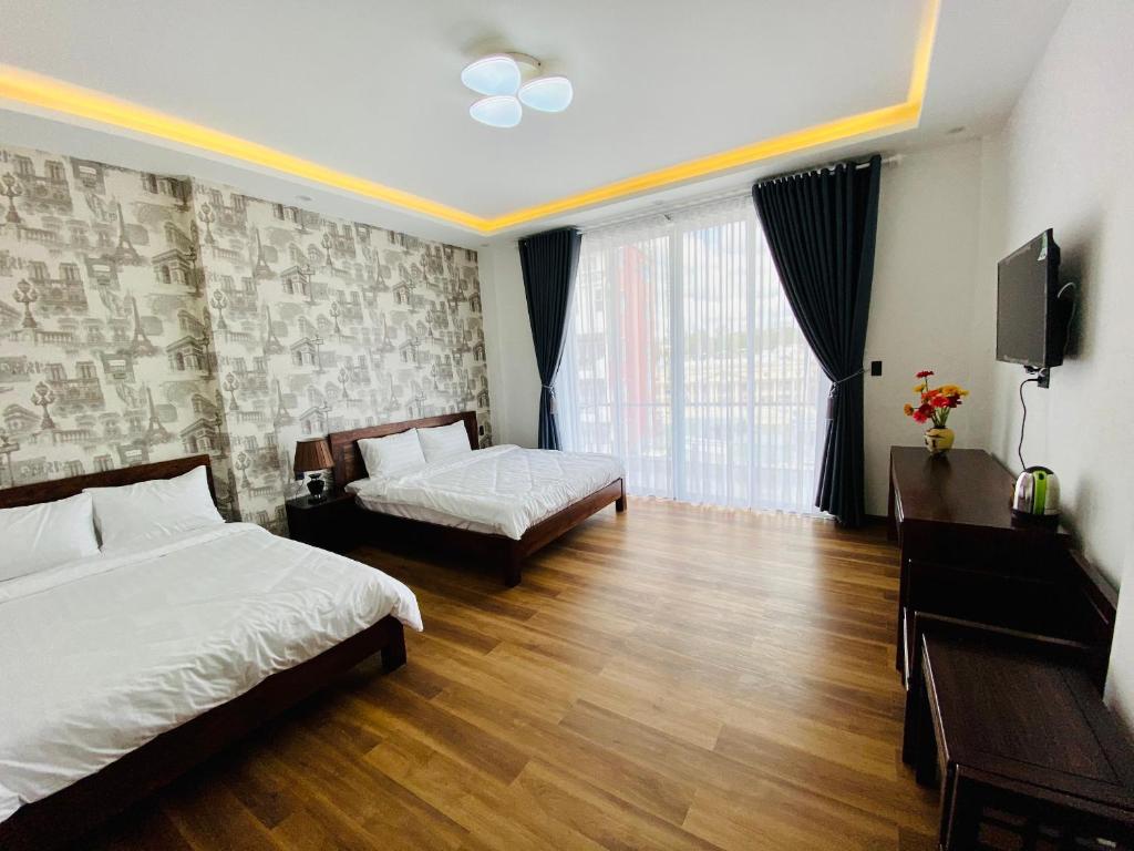 a hotel room with two beds and a television at Mỹ Lan hotel in Da Lat