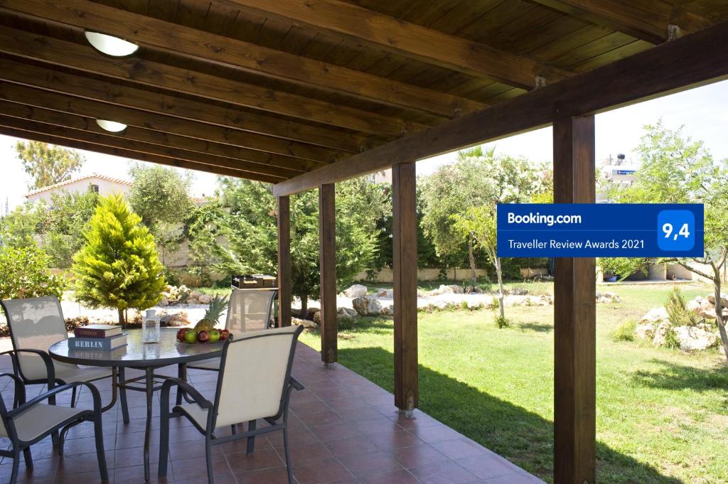 a patio with a table and chairs and a sign at Villa Nefeli in Stavros