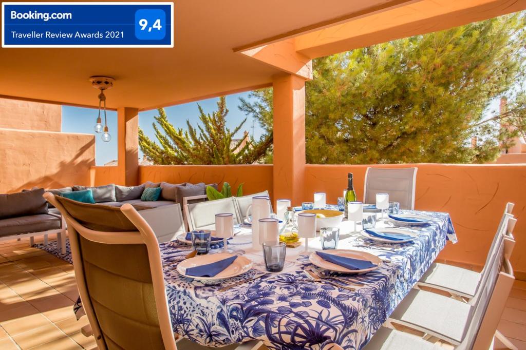 einen Tisch mit einem blauen und weißen Tischtuch auf einer Terrasse in der Unterkunft Ample Luxury Apart Fancy Marbella Golf & Padel in Marbella