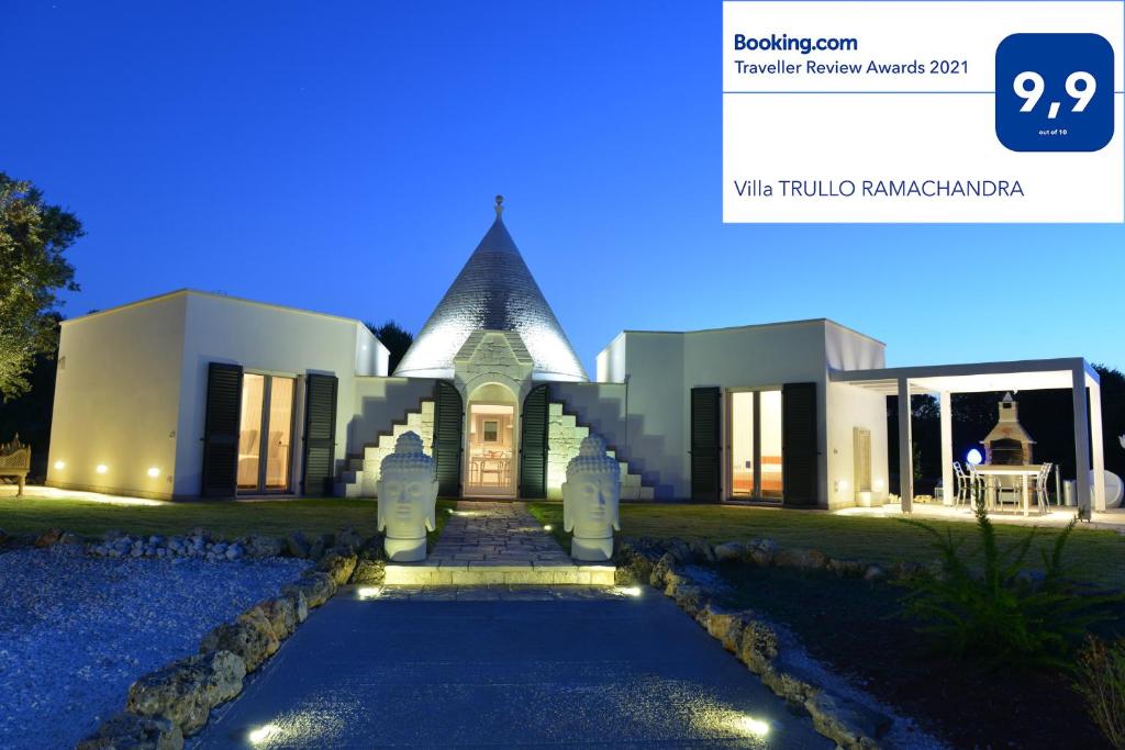 un grand bâtiment blanc avec un toit pointu dans l'établissement Villa TRULLO RAMACHANDRA, à Carovigno