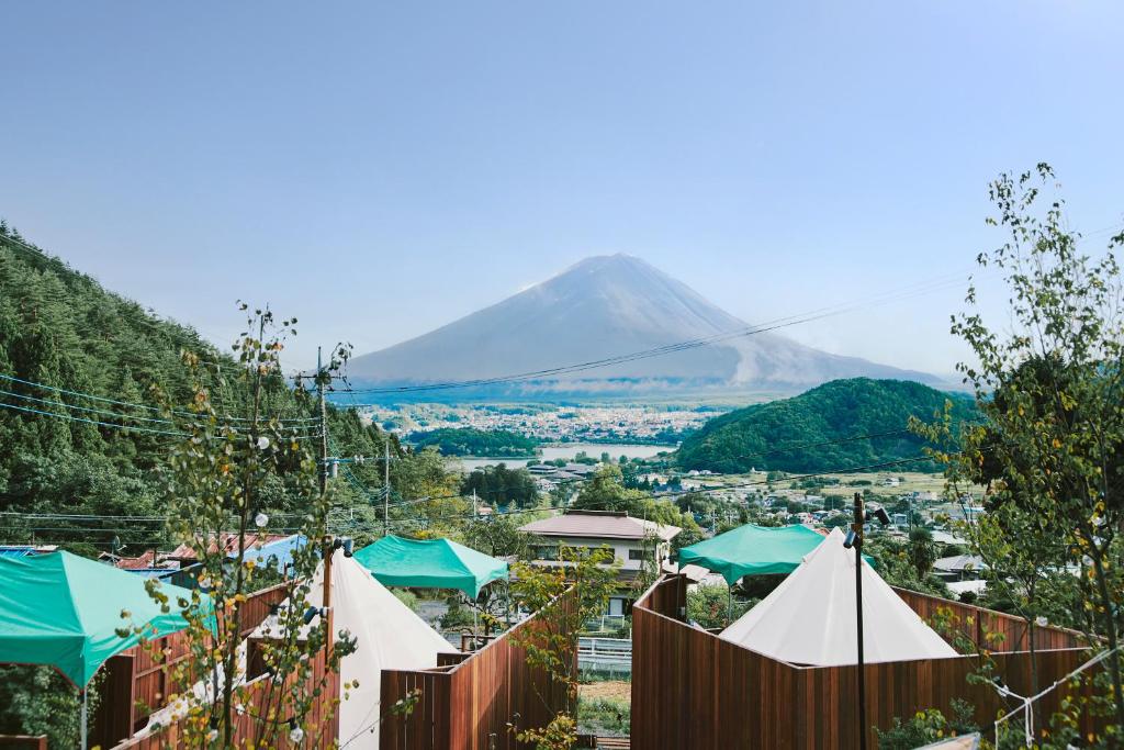 a view of a mountain with tents and a town at Dot Glamping 富士山 in Fujikawaguchiko