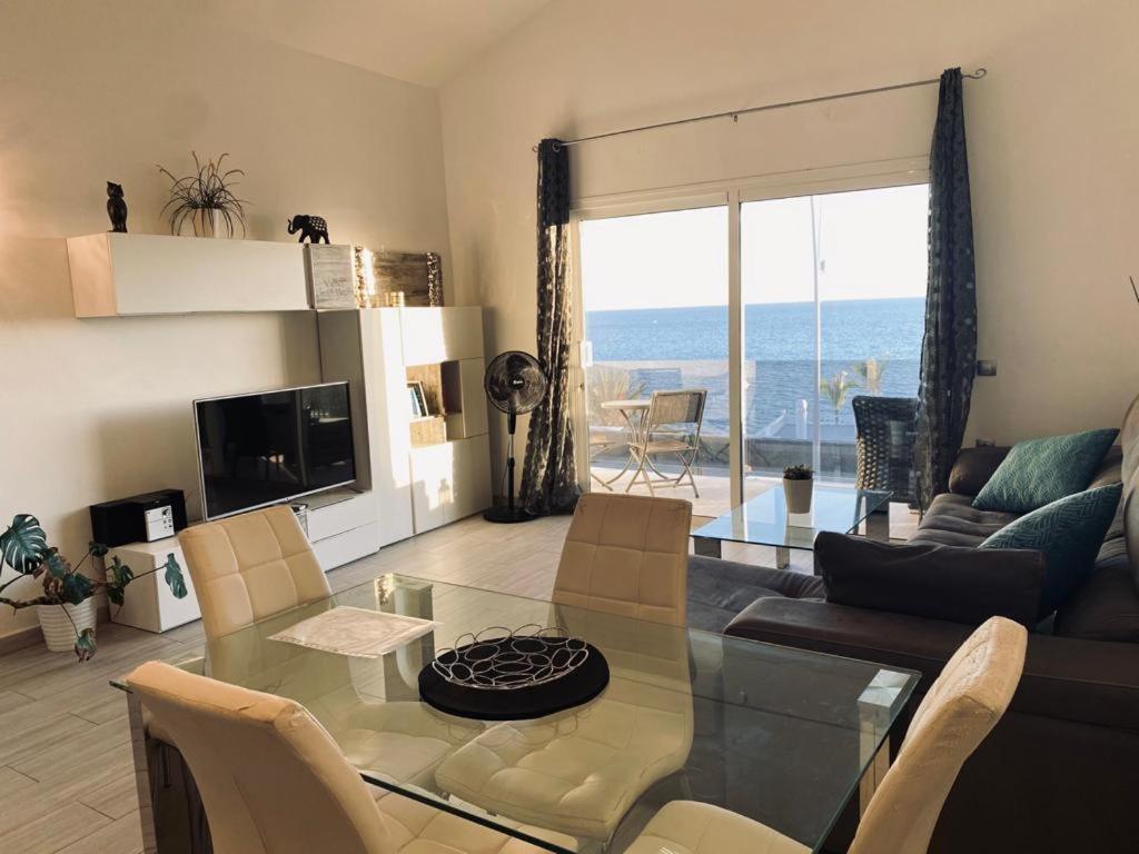 a living room with a glass table and a view of the ocean at Luxury Two Bed Seaviews in Puerto del Carmen