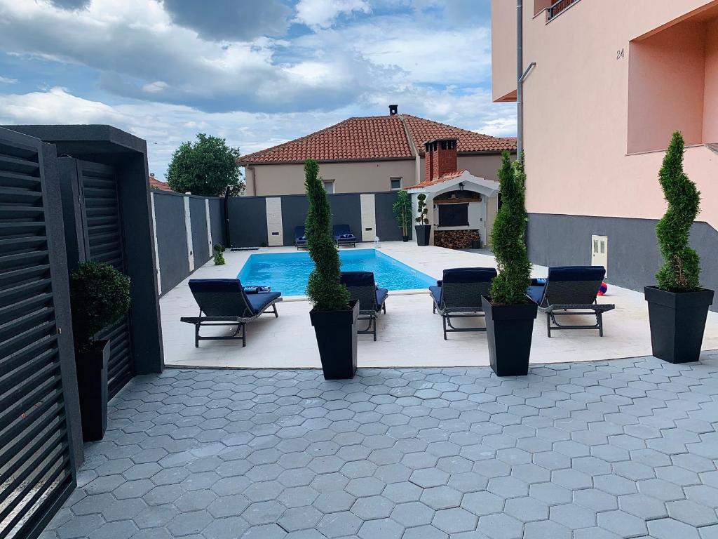 un patio con sillas, una piscina y una valla en Villa Balera, en Zadar