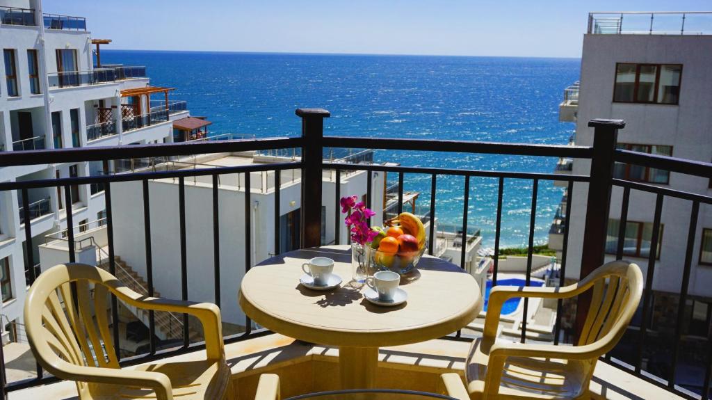 a table and chairs on a balcony with the ocean at Комплекс Бяла Виста до Плажа - Complex Byala Vista near the beach in Byala