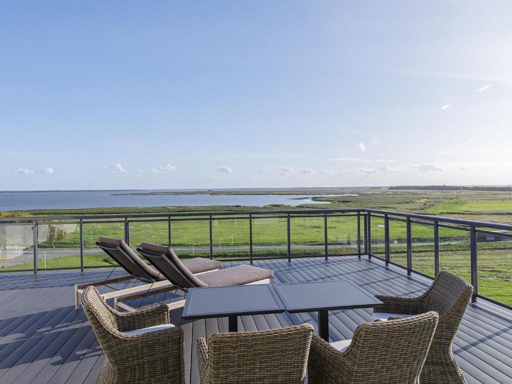 une terrasse avec une table et des chaises et l'océan dans l'établissement Alte Seefahrtschule am Ostseestrand, à Wustrow