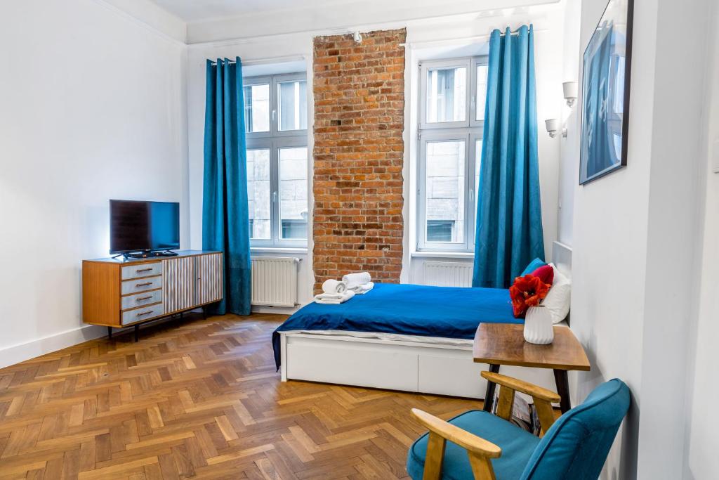 een slaapkamer met blauwe gordijnen en een bed en een stoel bij 2BCOMFY - Nad Niprem in Bielsko-Biala
