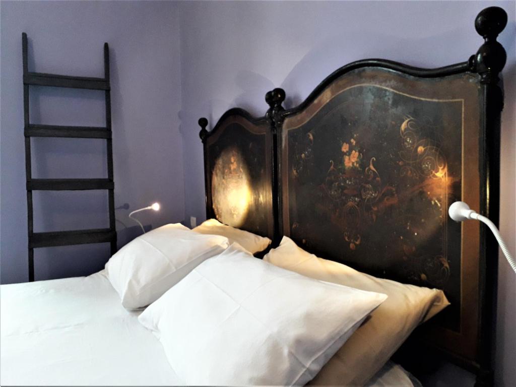 łóżko z drewnianym zagłówkiem i obrazem na ścianie w obiekcie I Templari B&B self-contained w mieście Brindisi