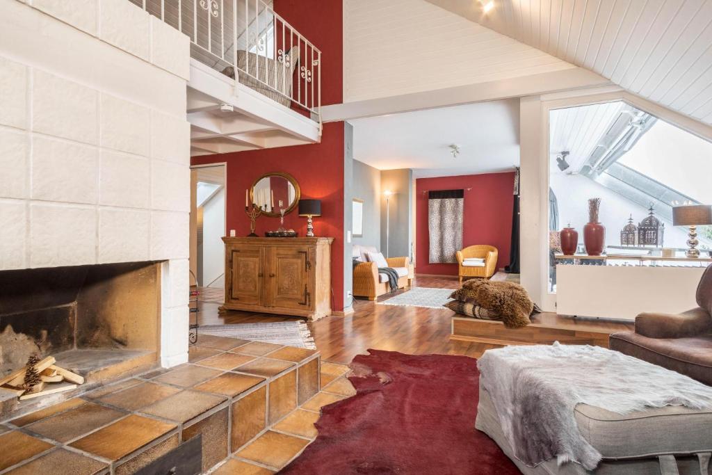 a living room with a fireplace and red walls at Dachatelier Überlingen in Überlingen