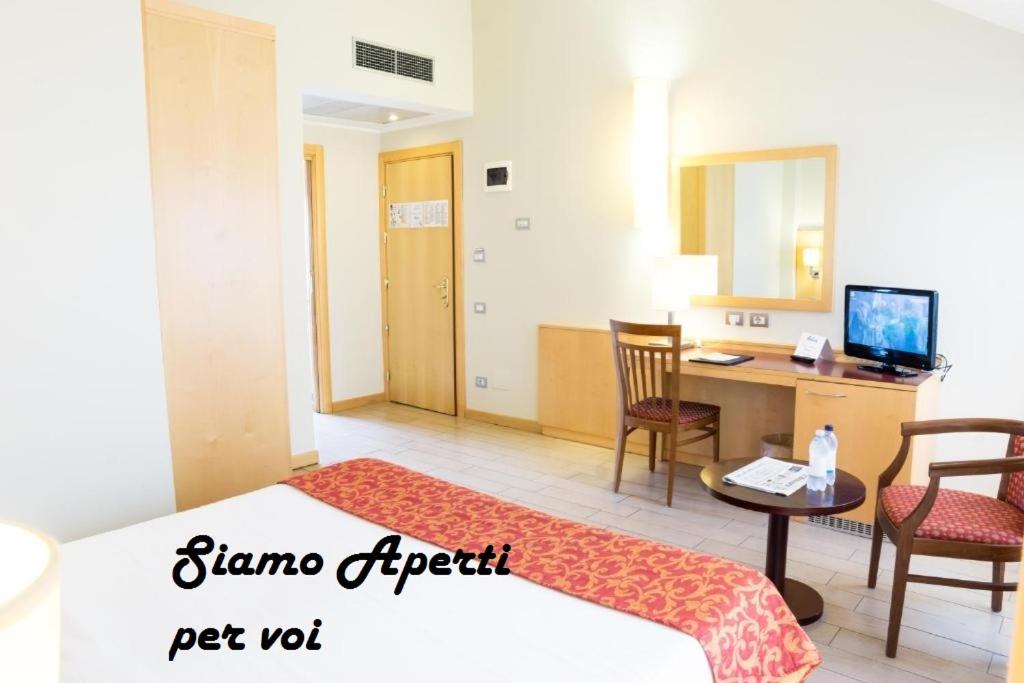 ミラノにあるScarlatti Hotel Milanoのベッド、デスク、コンピュータが備わるホテルルームです。