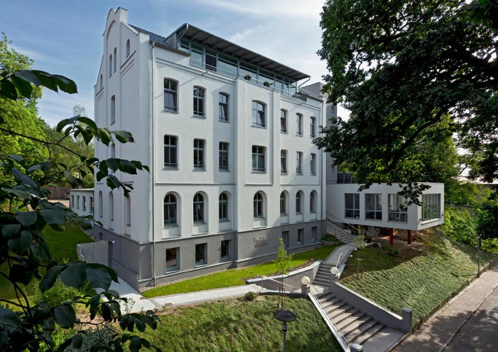 a white building with a staircase in front of it at Hotel zwischen den Seen in Waren