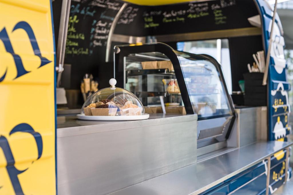 a food cart with a plate of food on a counter at Golden Tulip Marseille Euromed in Marseille