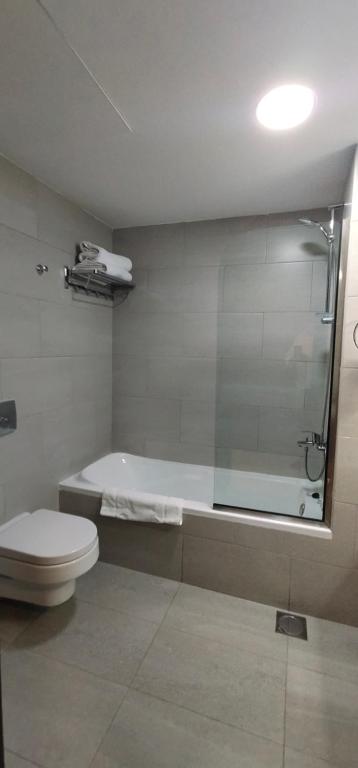 łazienka z wanną, toaletą i prysznicem w obiekcie Manazil Aldar Hotel w mieście Suhar