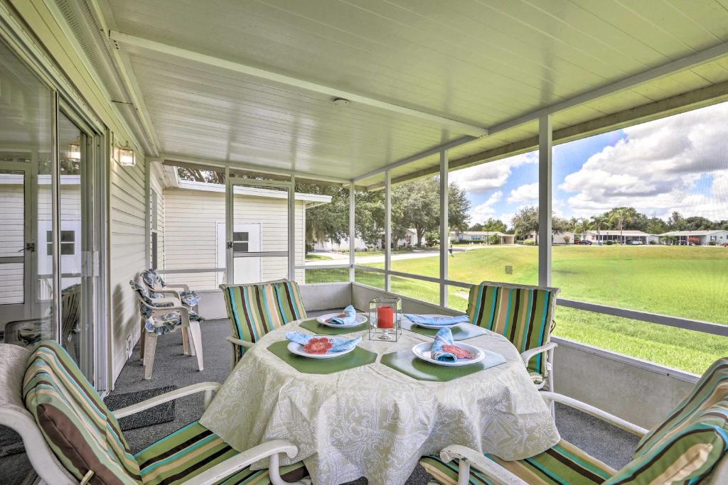 a table and chairs on a porch with a view of a field at Winter Garden House with Lanai and Pool Access! in Orlando
