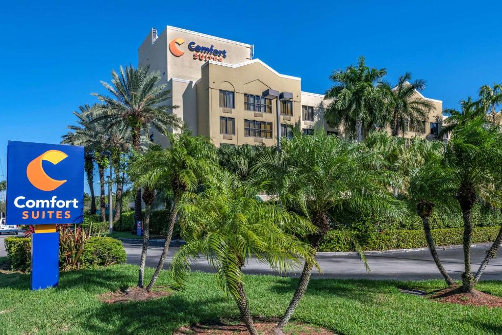 a resort with palm trees in front of a building at Comfort Suites Miami - Kendall in Kendall