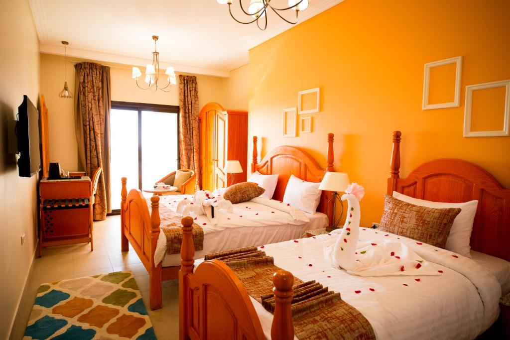 a bedroom with two beds and a living room at Holy Family Hotel in Jabal aţ Ţayr