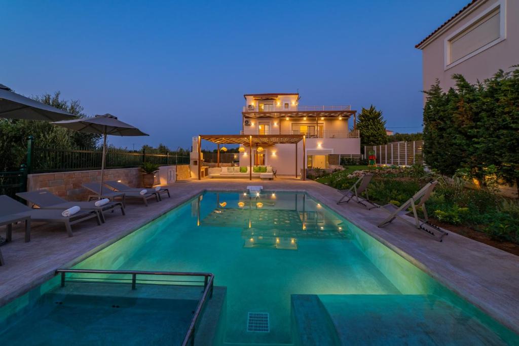 una piscina frente a una casa en Estella Villa with Pool, Children Area, BBQ & Magnificent Views!, en Astérion