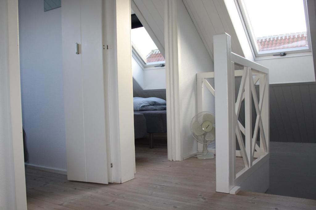 an attic hallway with an open door and a bedroom at Holiday-Skagen in Skagen