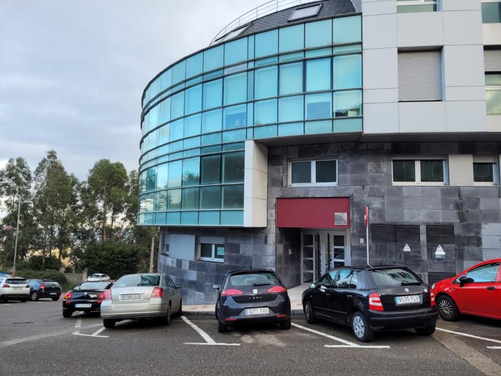 a parking lot with cars parked in front of a building at Apartamentos Burela in Burela de Cabo
