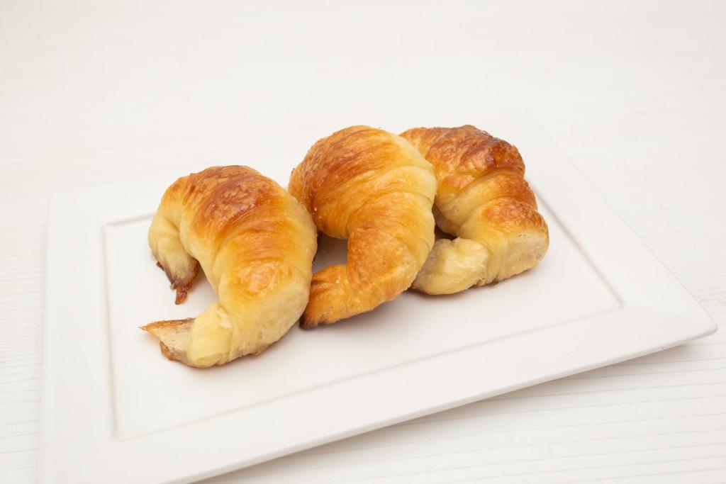 due croissant su un piatto bianco su un tavolo di Hotel Artico a Mar del Plata