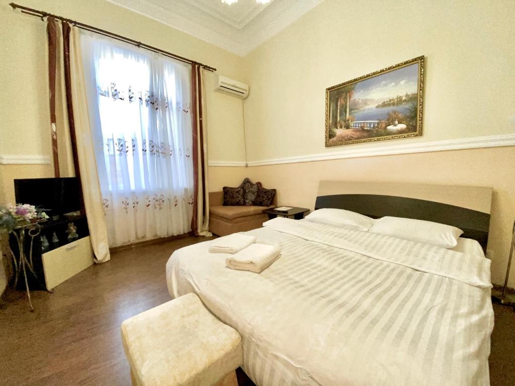 a bedroom with a large white bed and a window at ApartPoltava Будиночок з мангалом та терасою, Оглядовий майданчик, банківський чек in Poltava