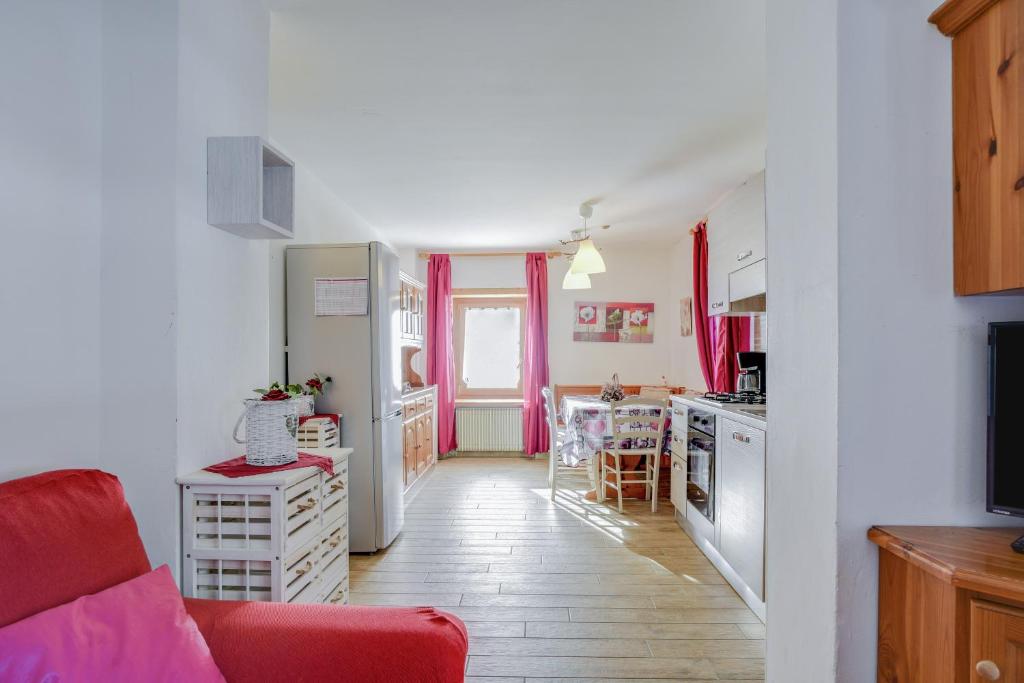 una cucina e un soggiorno con divano rosso di Cesa Crepaz a Canazei