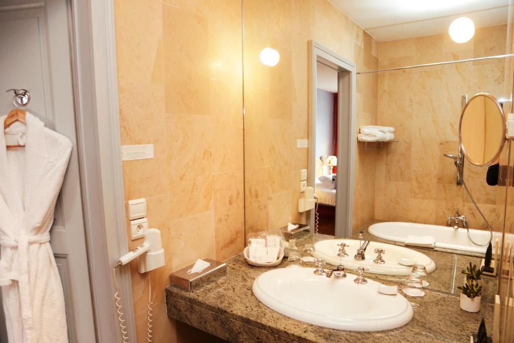 a bathroom with two sinks and a large mirror at Hotel D&#39;haussonville in Nancy