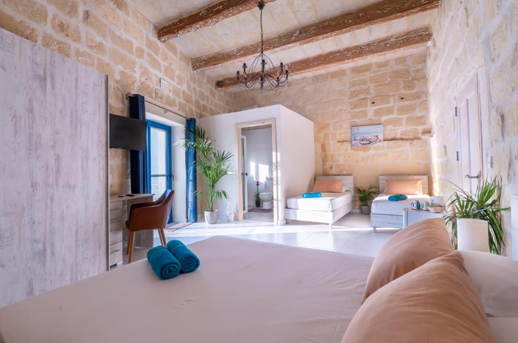a large room with a bed and a living room at Fiftyfour West Boutique Living in Għarb