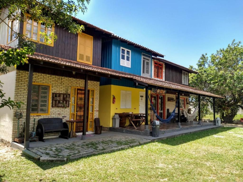 a house with a wrap around porch at Chalés Caminhos Do Rosa in Praia do Rosa
