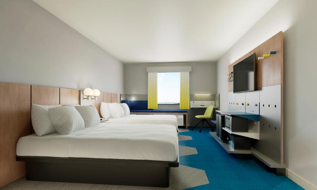 美貢提克湖的住宿－Microtel Inn Suites by Wyndham Lac-Megantic，酒店客房设有一张大床和一张书桌。