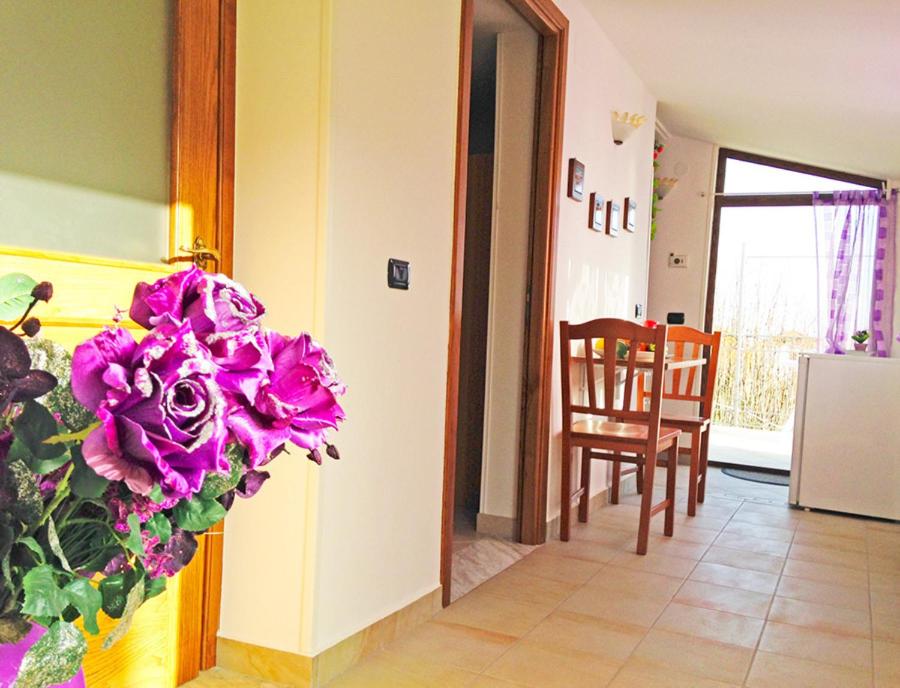 una sala de estar con flores púrpuras en la pared en Holidays Costanza, en Agerola
