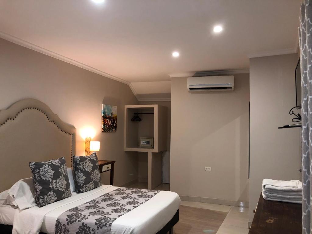 a bedroom with a bed and a room with a heater at Hotel Galeria la Trinidad in Cartagena de Indias