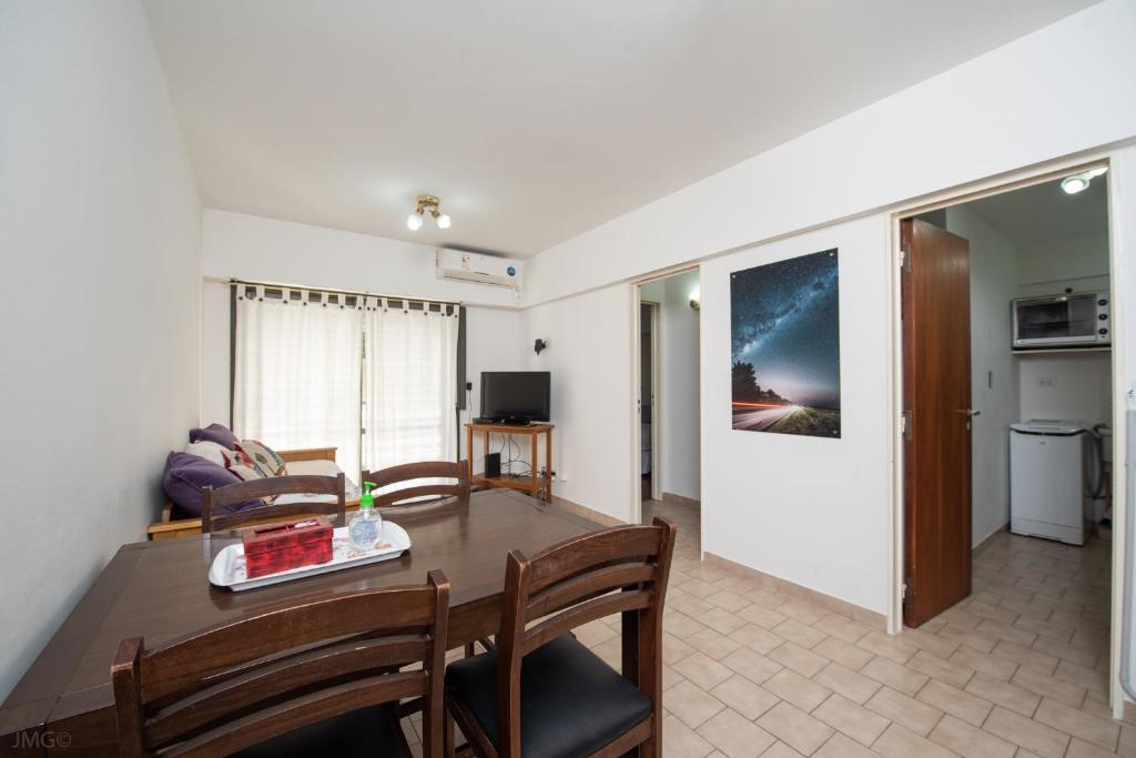 a living room with a table and a dining room at Apartamento Micro Centro para 4 con cochera in Bahía Blanca