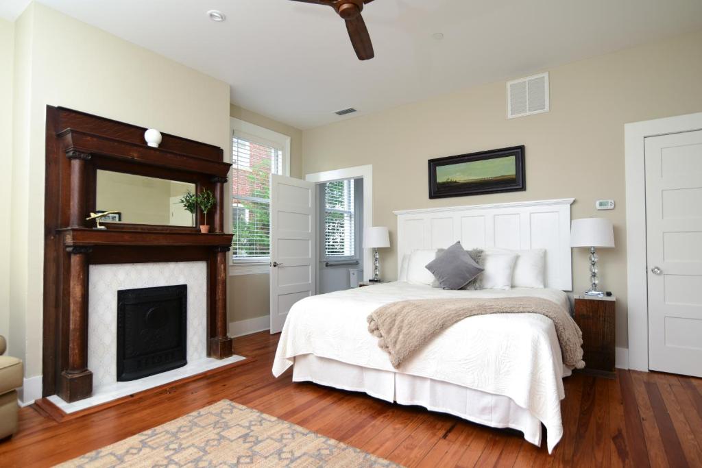 a bedroom with a bed with a fireplace and a mirror at 607 Bay Inn Downtown Beaufort in Beaufort
