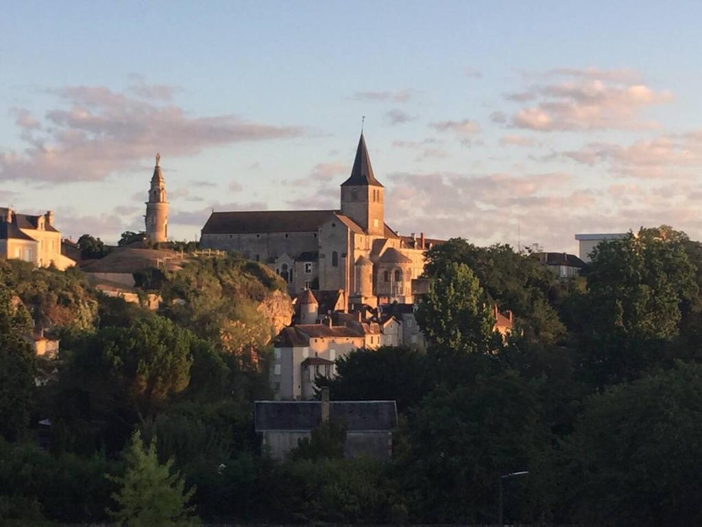 una ciudad en la cima de una colina con una iglesia en 2 bed apartment fantastic roof terrace-town centre, en Montmorillon