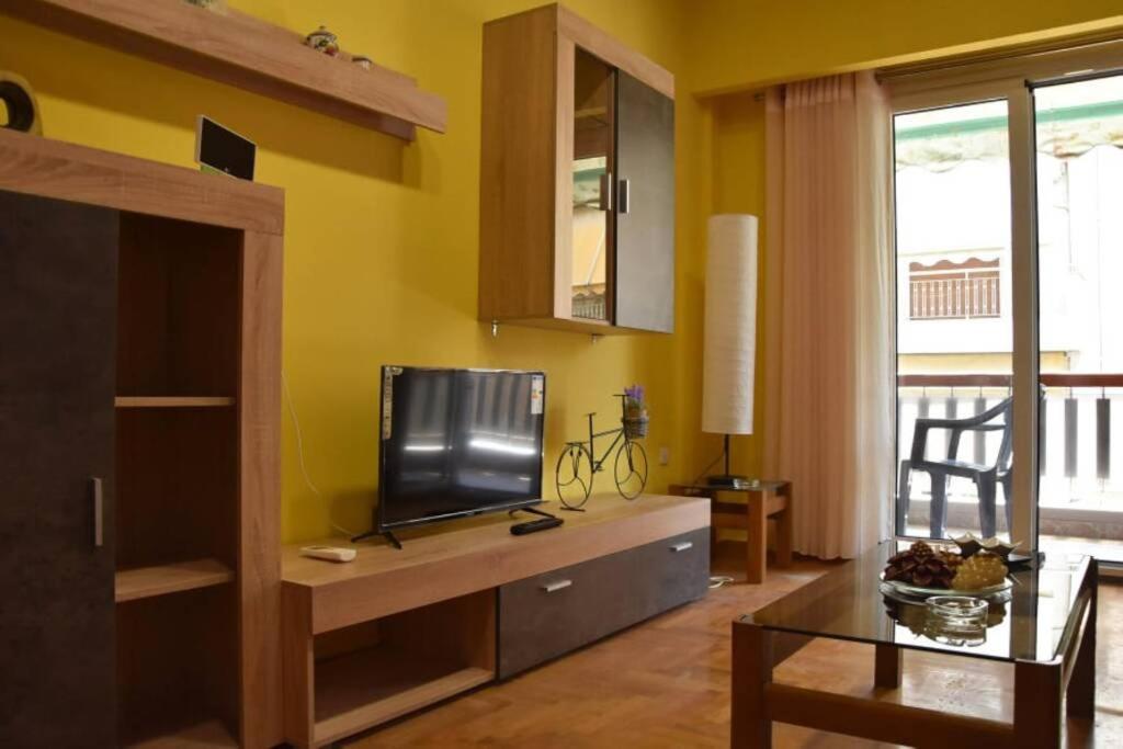 uma sala de estar com uma televisão de ecrã plano sobre uma mesa em Colourful Apartment in AthensCity 1min from Subway em Atenas