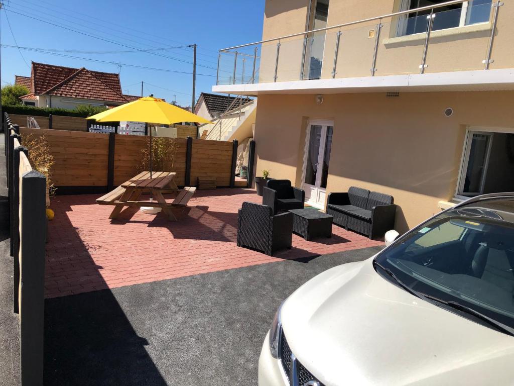 un coche blanco estacionado frente a una casa con una mesa de picnic en L' ALBATROS - 2 chambres - 5 personnes - Proximité de la plage en Bréhal