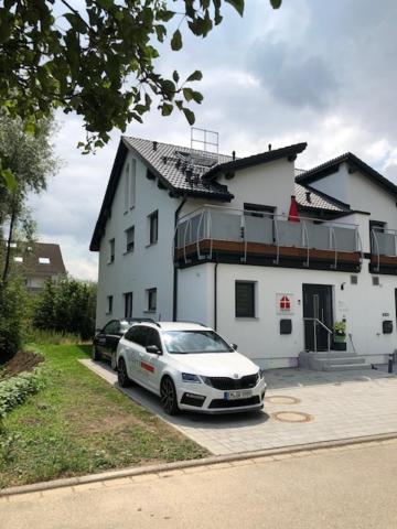 a white car parked in front of a white house at Ferienwohnung Anemone in Bahlingen