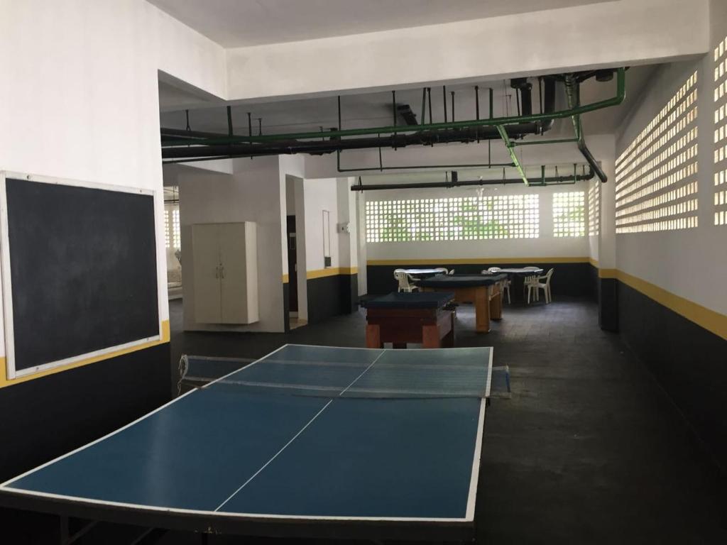 a classroom with a ping pong table and a blackboard at Apartamento Guaruja Pitangueiras in Guarujá