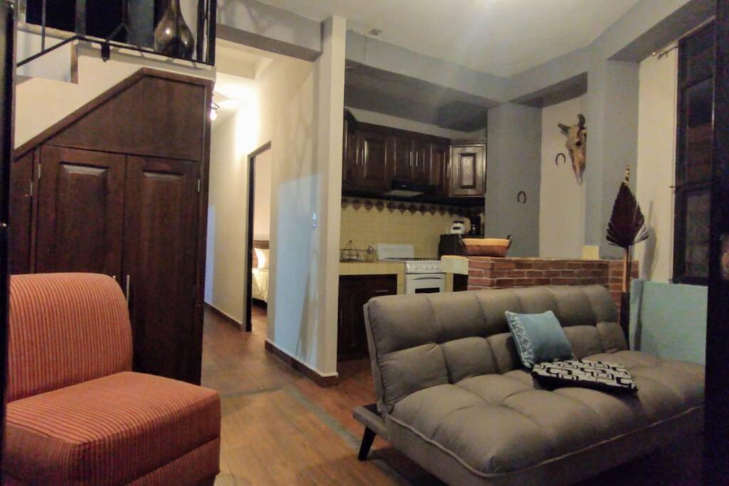 ein Wohnzimmer mit einem Sofa und einer Küche in der Unterkunft Embajadoras Apartment & Rooftop in Guanajuato