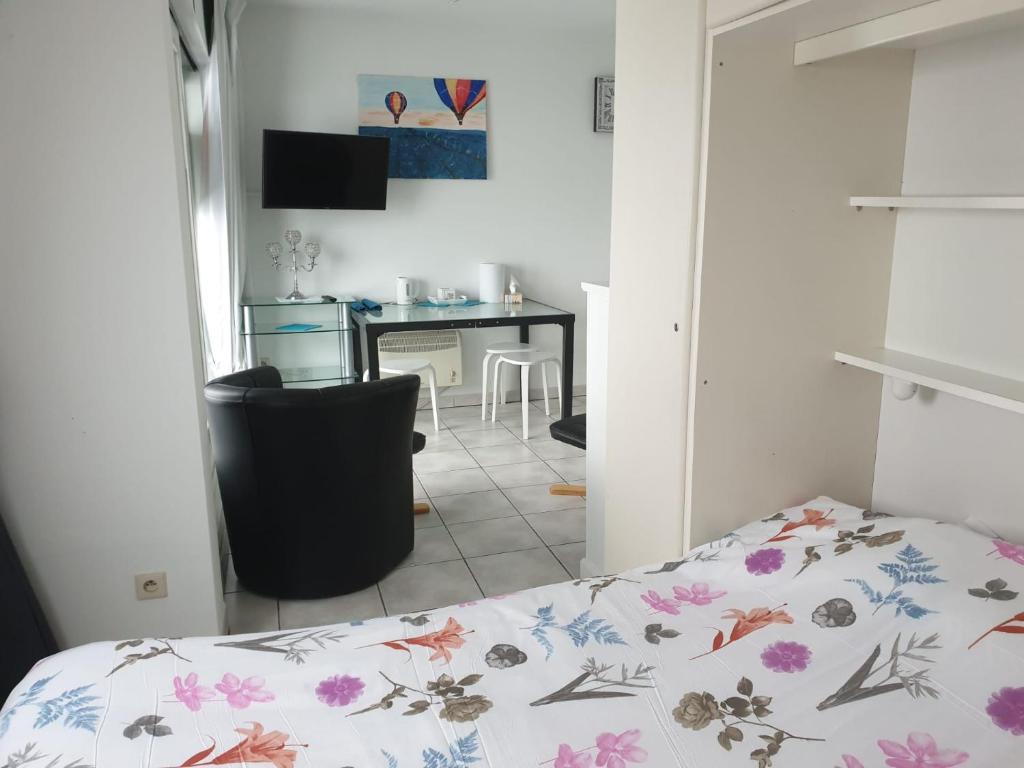 Un dormitorio con una cama y un comedor con una mesa. en Beachfront Studio in Blankenberg (Belgium), en Blankenberge