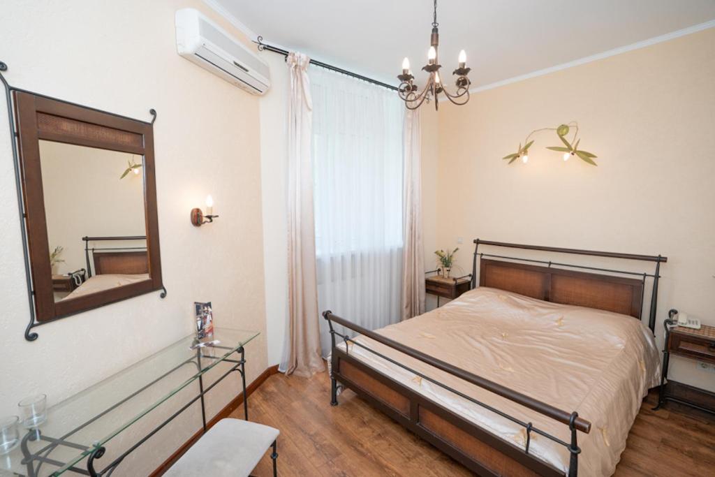 1 dormitorio con cama y espejo en la pared en Hotel Piano en Kiev