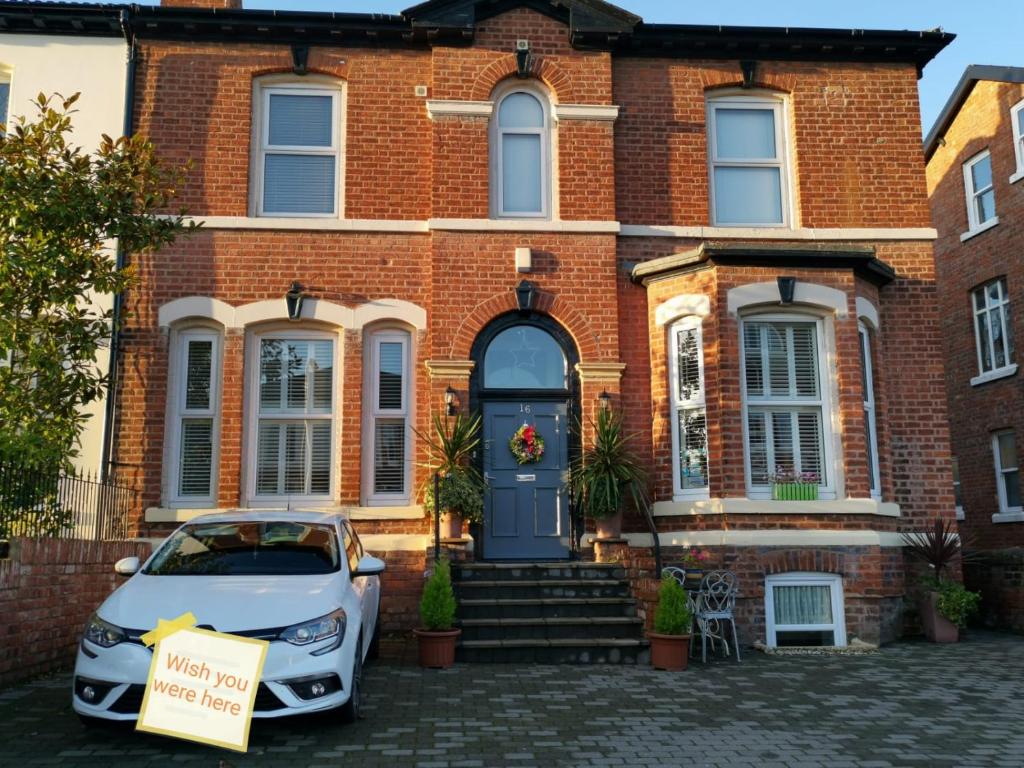 un coche blanco estacionado frente a una casa de ladrillo en Vale House, en Southport