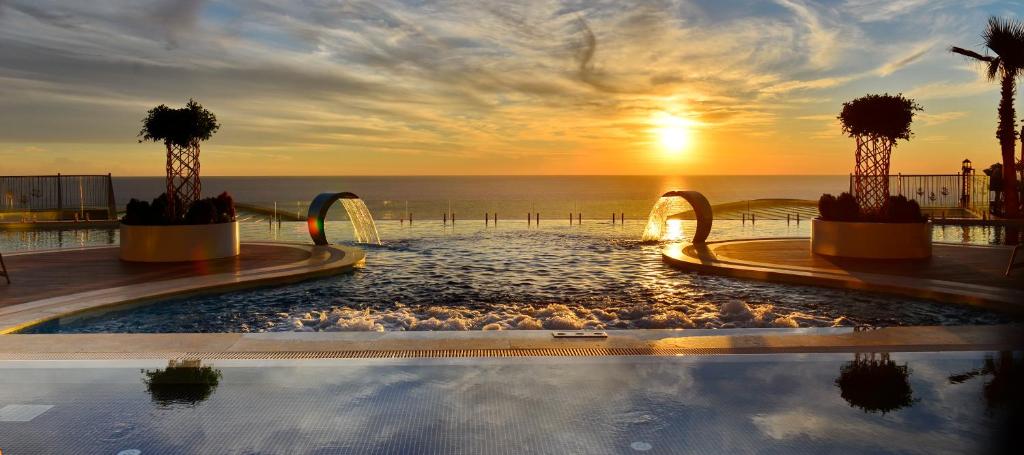 una piscina con puesta de sol en el fondo en Elite Luxury Suite & Spa en Alanya
