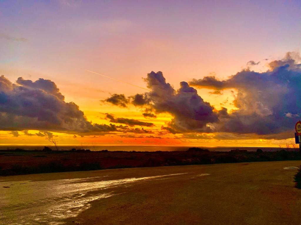 a sunset over a river with a cloudy sky at Fiftyfour West Boutique Living in Għarb