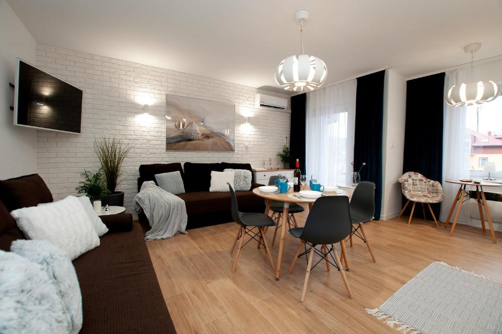 uma sala de estar com um sofá e uma mesa em Apartament IKAR ul. Grunwaldzka blisko morza em Pobierowo