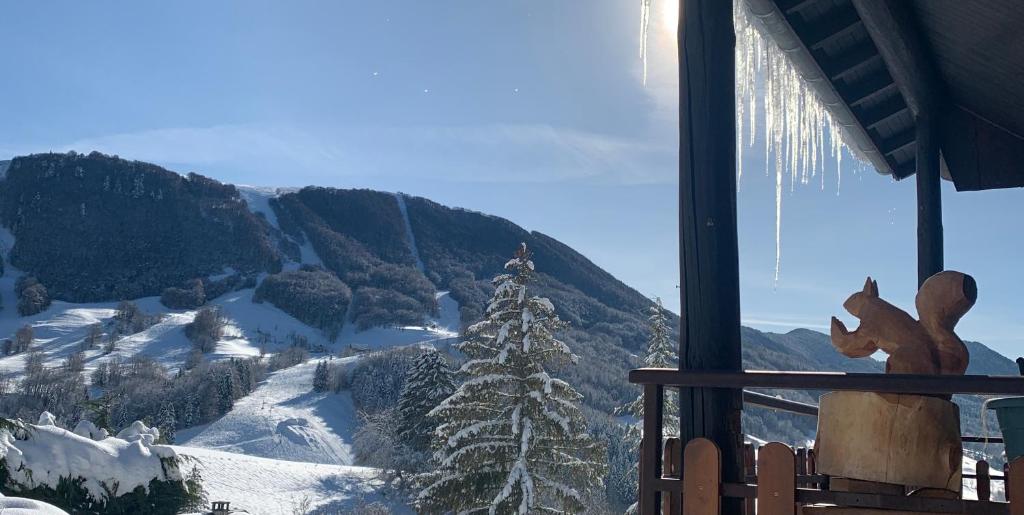 a ski lodge with a view of a snowy mountain at L’Eterle in Aillon-le-Jeune