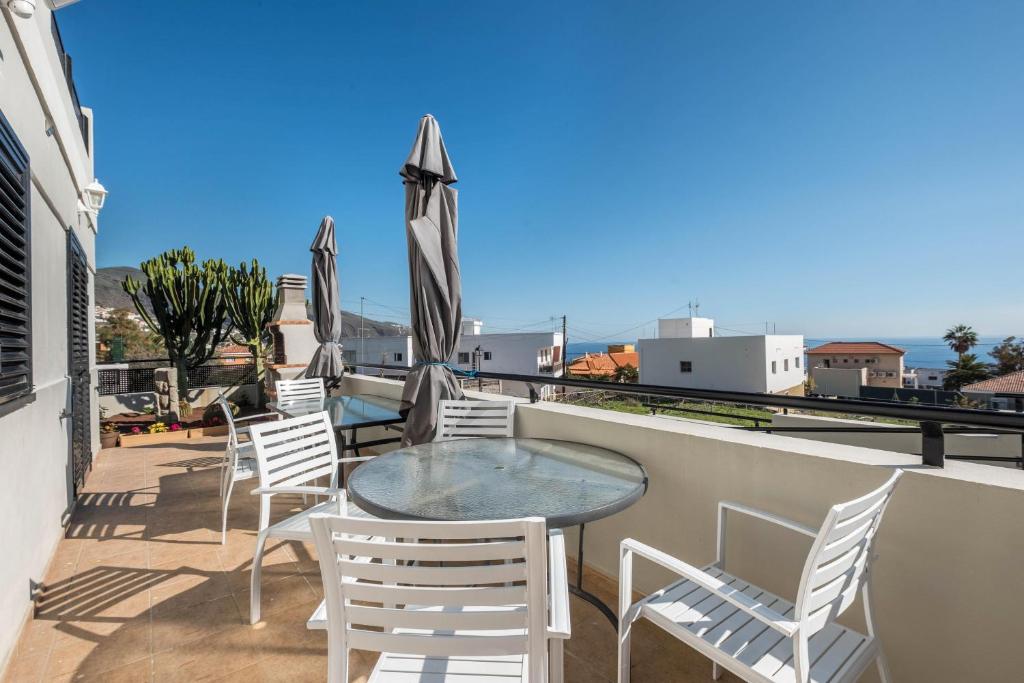 balkon z krzesłami i stołem na dachu w obiekcie Candelaria Relax w mieście Candelaria