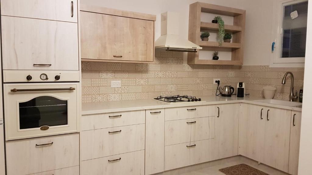 a kitchen with white cabinets and a stove top oven at Suit November in Majdal Shams